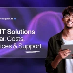 A purple-themed promotional banner with a futuristic, wavy grid pattern in the background. A young, smiling man with glasses is on the right side of the image, holding a tablet and looking directly at the camera. He is wearing a dark, corduroy-like jacket over a white t-shirt. On the left side, a large, translucent, rounded rectangle contains the text "Top IT Solutions Dubai: Costs, Services & Support". The words "IT Solutions" are highlighted in bold. At the top left of the rectangle, the logo for "ZAB-Tech" is visible along with the website address "zabtechdigital.ae". The design is modern, professional, and tech-oriented.