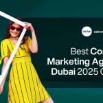 A lively promotional banner for a content marketing agency. The background is a dark teal color. On the left side, two young women are smiling and posing. The woman on the left has curly hair, is wearing sunglasses and a dark red patterned dress, and is holding a large white cutout frame shaped like an Instagram post. The woman on the right is wearing sunglasses and a bright yellow striped dress with a white belt and is smiling. On the right side of the banner, contained within a large, rounded black overlay, is the text: "Best Content Marketing Agency Dubai 2025 Guide". At the top of this section, the logo for ZAB-Tech and the website address "zabtechdigital.ae" are visible. The overall design is energetic, modern, and focused on digital and content marketing.